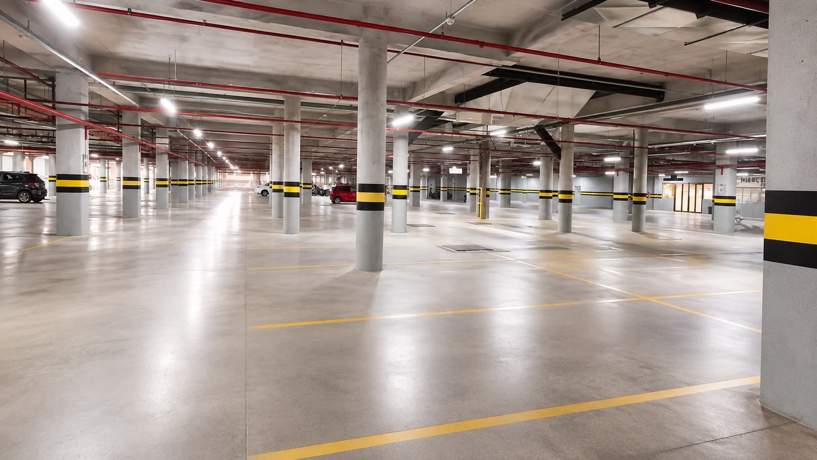 Estacionamento coberto do Shopping Dubai, com vagas amplas e colunas sinalizadas